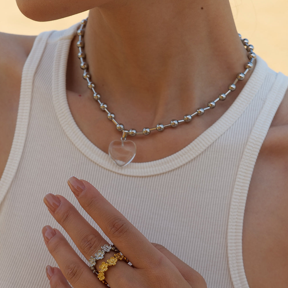 Damen Halskette mit transparentem Herzanhänger und goldene Kugel-Details Shop Nory