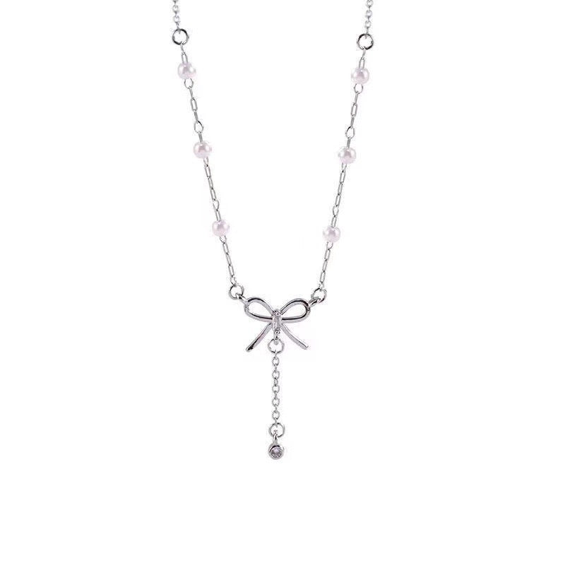 Damen Kette mit zartem Schleifenanhänger und eleganten Perlendetails Shop Nory