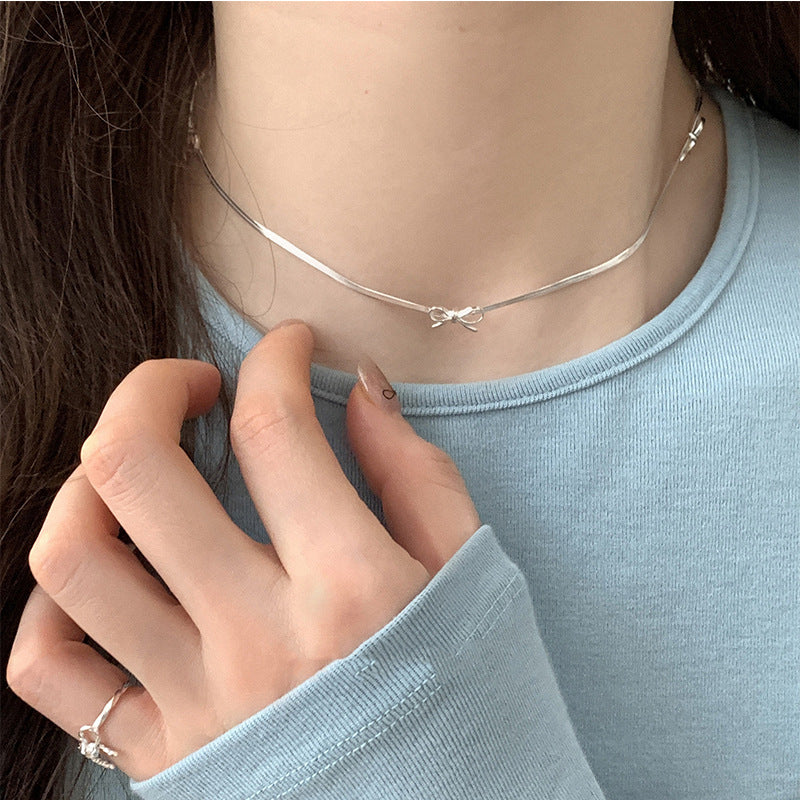 Damen Halskette mit geschwungenem Design und zartem Schleifenanhänger Shop Nory