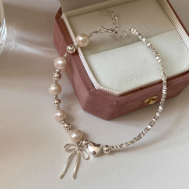 Damen Schmuckarmband mit filigranem Schleifenanhänger und hochwertigen Perlen Shop Nory