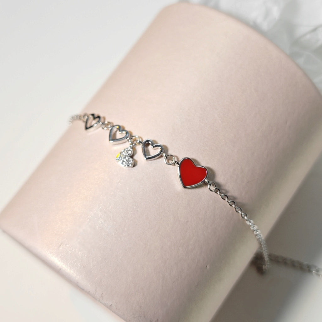 Damen Armband mit herzförmigen Anhängern und funkelnden Kristallelementen Shop Nory