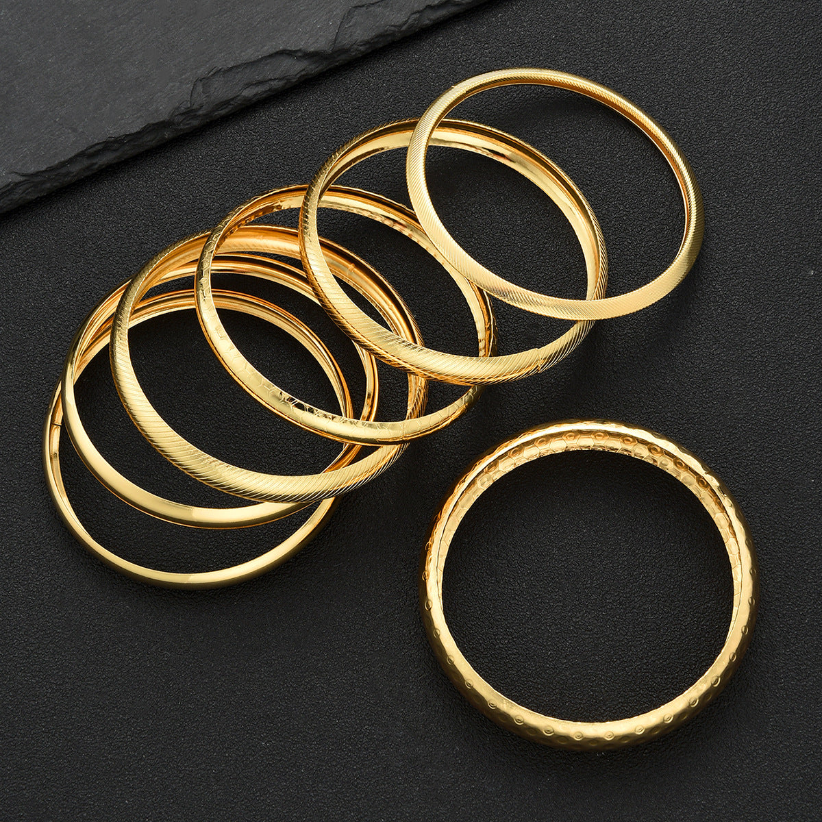Damen Armreif-Set mit variierenden Oberflächentexturen und glänzenden Akzenten Shop Nory