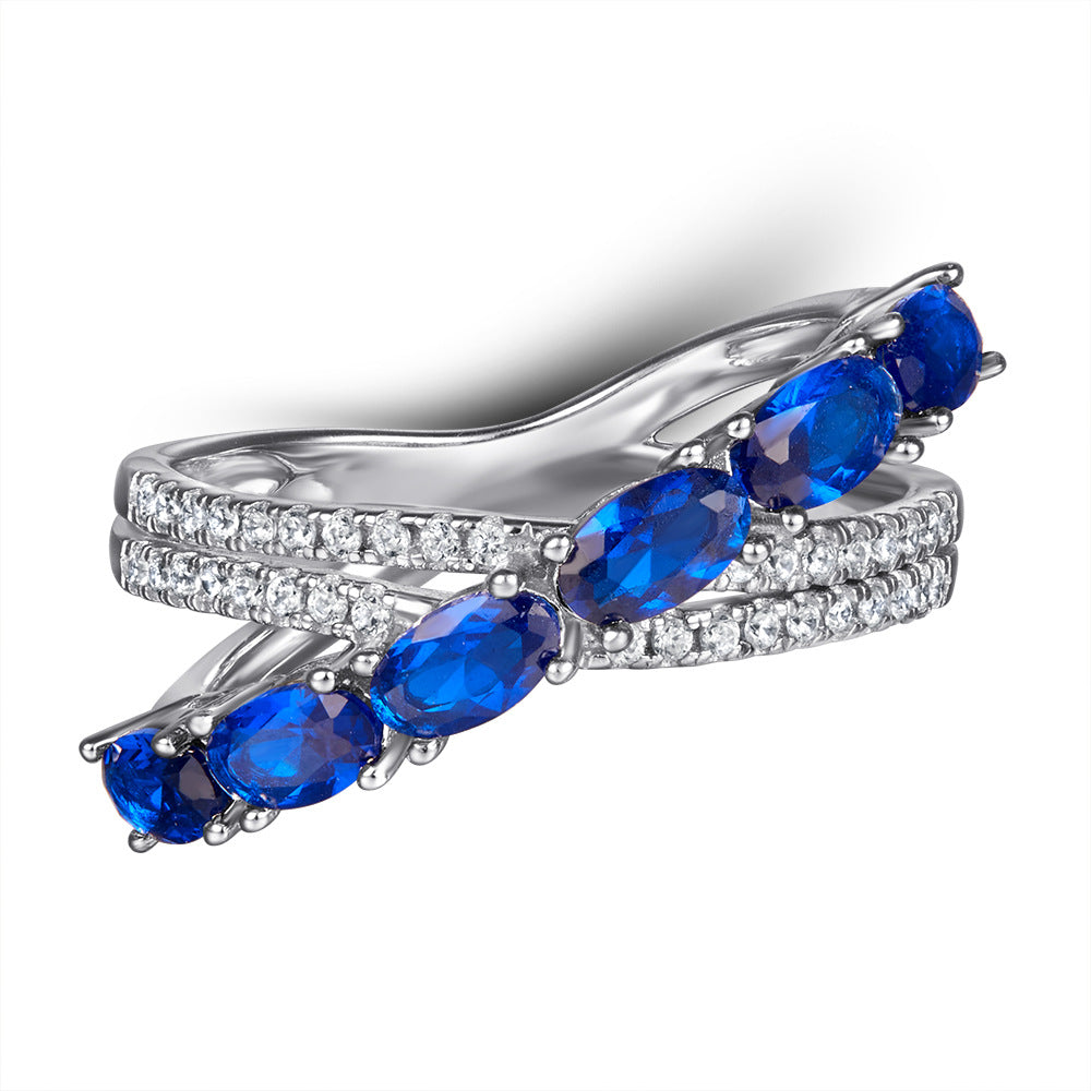 Damen Ring mit funkelnden blauen Zirkonia und eleganter, geschwungener Fassung Shop Nory