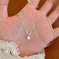 Damen Halskette mit zartem Perlenanhänger und exquisiten silbernen Details Shop Nory