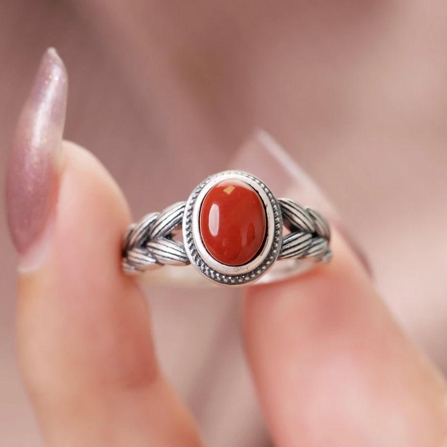 Damenring mit kunstvollem geflochtenem Design und rotem Zierstein Shop Nory