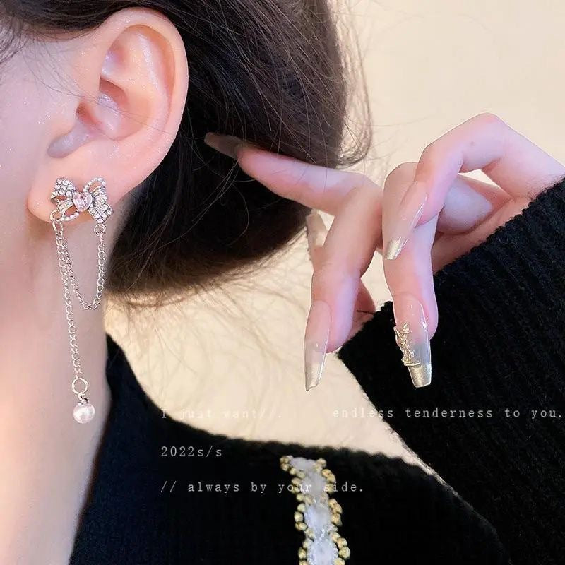 Damen Ohrringe mit filigranem Schleifen-Design und funkelnden Perlendetails Shop Nory