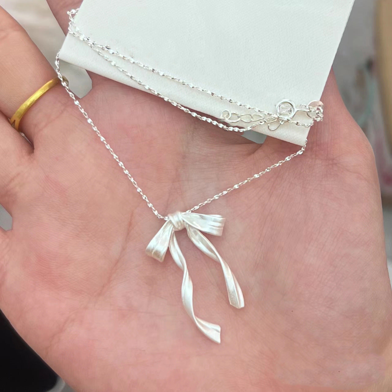 Damen Halskette mit kunstvollem Schleifenanhänger aus hochwertigem Material Shop Nory
