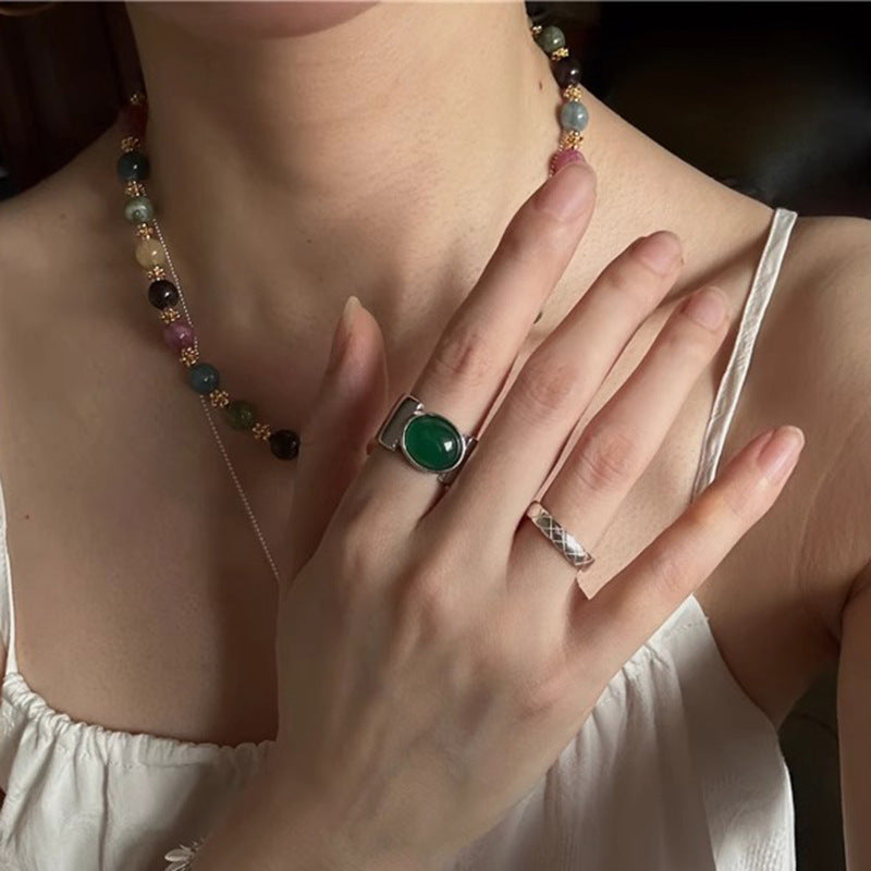 Damenring mit elegantem, geschwungenem Design und grünem Stein Shop Nory