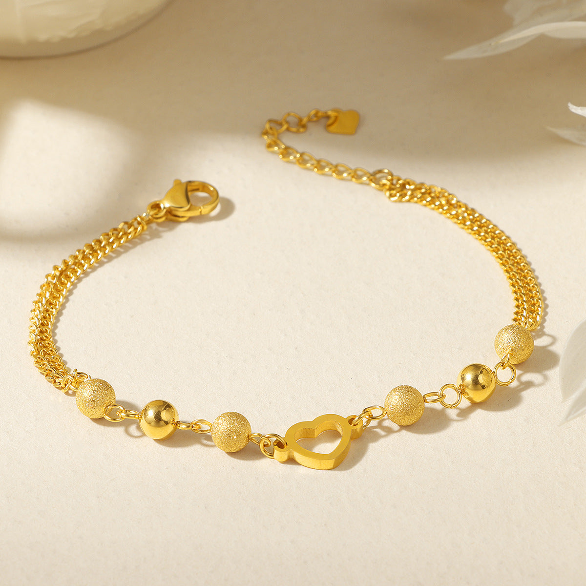 Damen modisches Armband mit funkelnden Kugeldetails und Herzanhänger Shop Nory