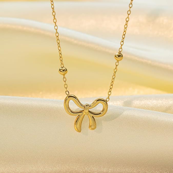 Damen Halskette mit filigranem Schleifenanhänger und glänzenden Kugeldetails Shop Nory