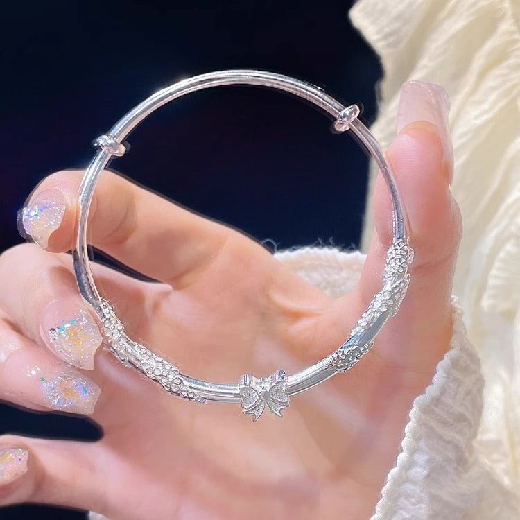 Damenarmreif mit floralem Design und verspieltem Schleifenanhänger Shop Nory