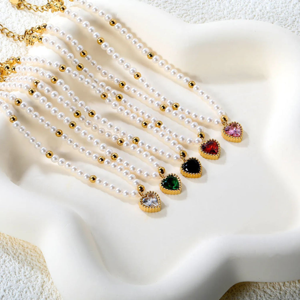 Damen Armband mit schimmernden goldenen Perlen und funkelndem Herzanhänger Shop Nory