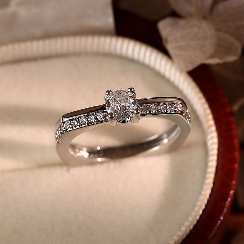 Damen Eleganter Verlobungsring mit funkelndem zentralen Stein und dezenten Zirkonia Shop Nory