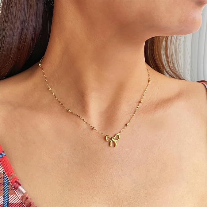 Damen Halskette mit filigranem Schleifenanhänger und glänzenden Kugeldetails Shop Nory