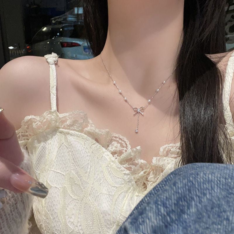 Damen Kette mit zartem Schleifenanhänger und eleganten Perlendetails Shop Nory
