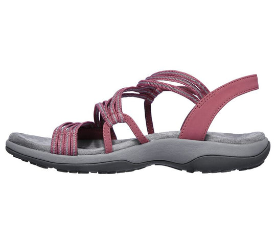 Rosafarbene orthopädische Sandalen mit überkreuzten Riemen auf weißem Hintergrund