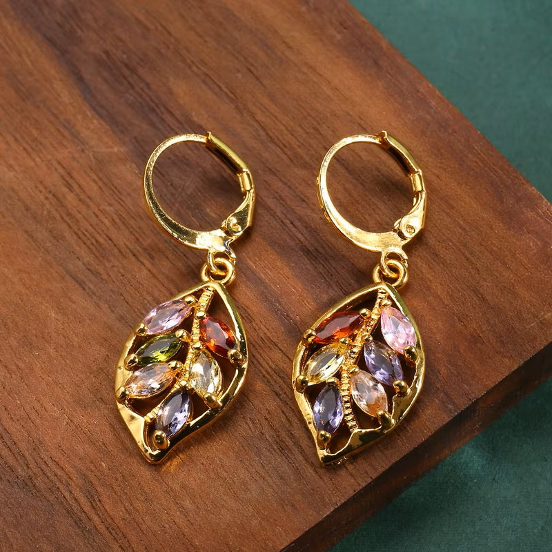Damen Ohrringe mit goldenem Blatt, eingelegten farbigen Kristallen und Anhängern | Shop Nory