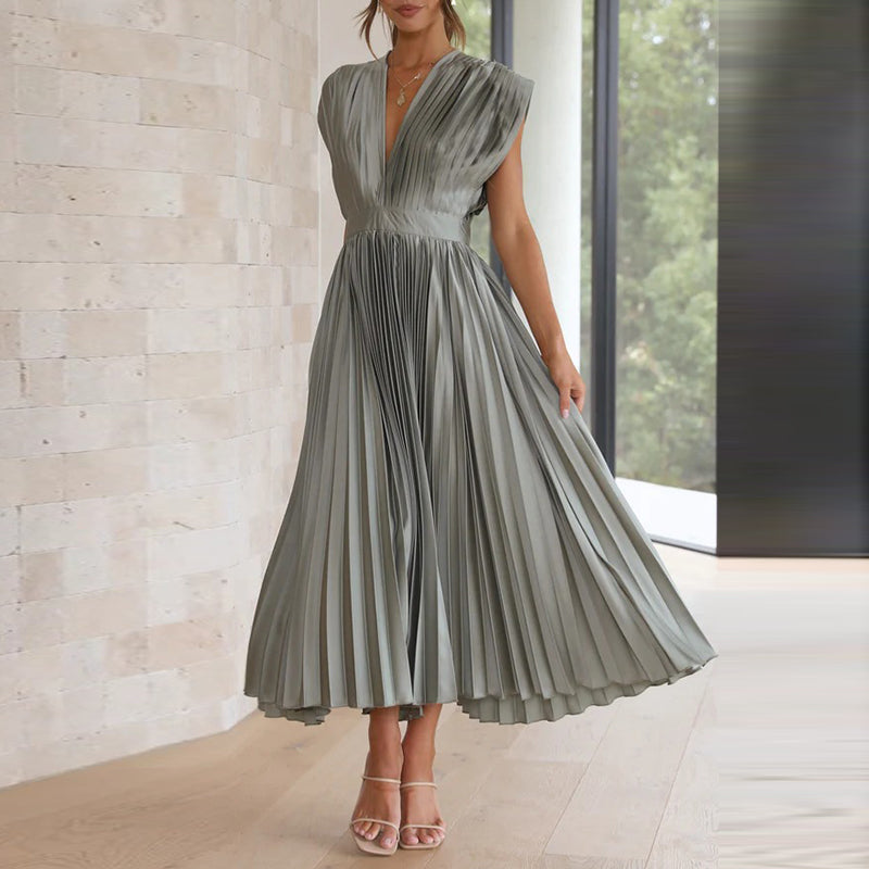 Model in einem grau kleid mit v-ausschnitt, stehend in einem modernen innenraum mit großen fenstern